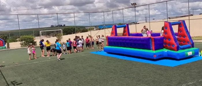 Crianças se divertindo no Futebol de Sabão inflável durante festa infantil em Cascavel-PR.